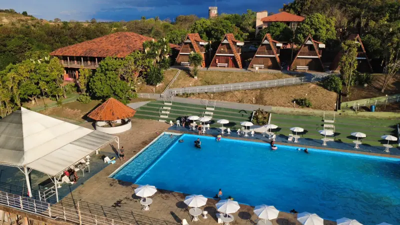 Vista do alto: piscina, chalés e gramado